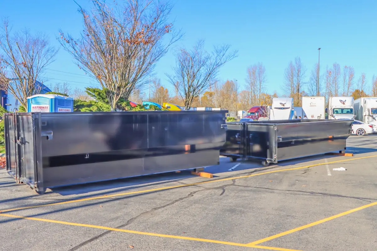 Professional dumpster rental service with roll-off container on residential driveway in Bluefield